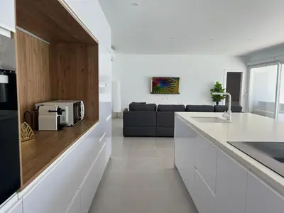 a kitchen and living room with a couch in the background at El Paraíso in Chiclana de la Frontera