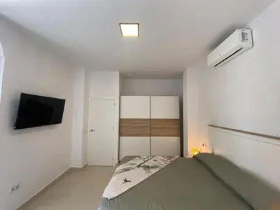 a bedroom with a bed and a flat screen tv at Sol Sherry in Jerez de la Frontera