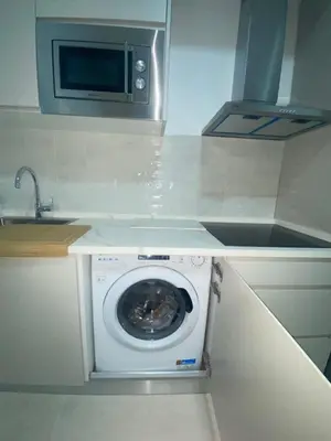a kitchen with a washing machine and a microwave at Sol Sherry in Jerez de la Frontera