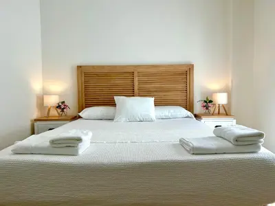a bedroom with a large bed with two towels on it at GATU Palacio de Rosa SOLO Familias in El Puerto de Santa María