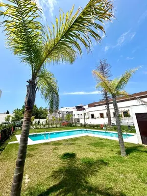 a palm tree next to a swimming pool at GATU Palacio de Rosa SOLO Familias in El Puerto de Santa María