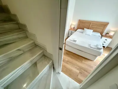 a small room with a bed and two stairs at GATU Palacio de Rosa SOLO Familias in El Puerto de Santa María
