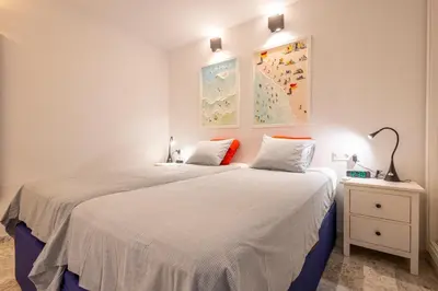 a bedroom with two beds with white sheets and orange pillows at Cadizz - Ático del Búho Surenyo - Terraza 100m2 privada in Cádiz