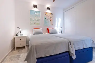 a bedroom with a large bed with a blue bed frame at Cadizz - Ático del Búho Surenyo - Terraza 100m2 privada in Cádiz