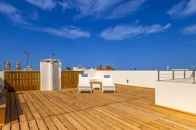 two chairs and a table on a wooden deck at Cadizz - Ático del Búho Surenyo - Terraza 100m2 privada in Cádiz