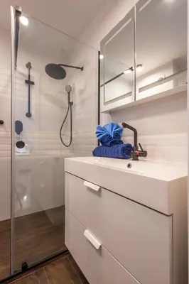 a white bathroom with a sink and a shower at Cadizz - Ático del Búho Surenyo - Terraza 100m2 privada in Cádiz