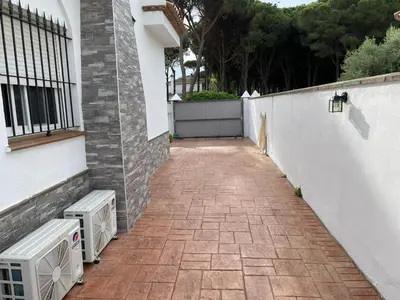 a brick walkway next to a white wall with two air conditioners at Azafama Buena in Chiclana de la Frontera