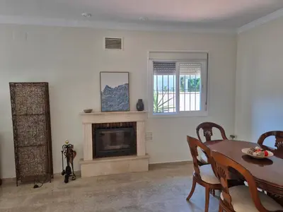 a living room with a table and a fireplace at Azafama Buena in Chiclana de la Frontera