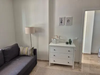 a living room with a couch and a white dresser at Azafama Buena in Chiclana de la Frontera