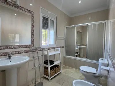 a bathroom with a sink and a toilet and a mirror at Azafama Buena in Chiclana de la Frontera