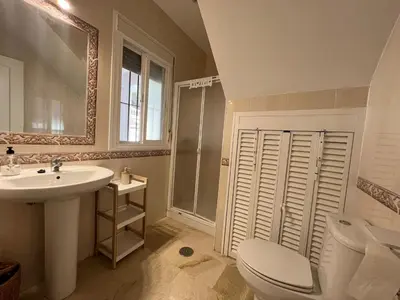 a bathroom with a sink and a toilet and a mirror at Azafama Buena in Chiclana de la Frontera