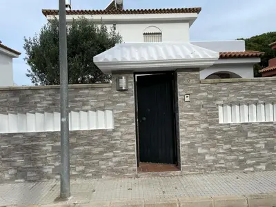 a building with a black door on a brick wall at Azafama Buena in Chiclana de la Frontera