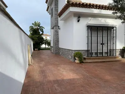 a white building with a gate on the side of it at Azafama Buena in Chiclana de la Frontera