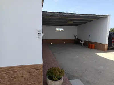 a building with a parking lot with a car garage at Lakuarta in Hozanejos