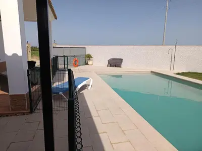 a swimming pool in front of a house at Lakuarta in Hozanejos