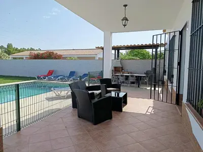 a patio with chairs and a table and a pool at Lakuarta in Hozanejos
