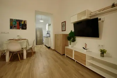 a living room with a dining room table and a kitchen at Luz del Sur en El Puerto de Santa María desde el corazón de su casco histórico in El Puerto de Santa María