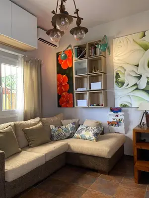 a living room with a couch and a painting of flowers at Puerto Sherry Bali in El Puerto de Santa María