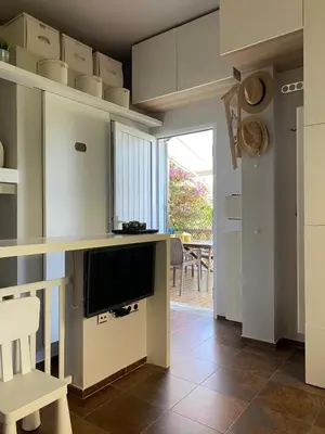 a living room with a television and a table at Puerto Sherry Bali in El Puerto de Santa María