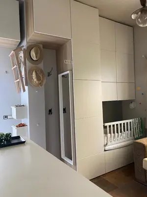 a kitchen with white cabinets and a baby crib at Puerto Sherry Bali in El Puerto de Santa María