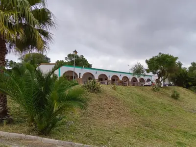 a building on top of a hill with a palm tree at Grupo El Duende A&G in San Jose del Valle