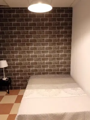 a bedroom with a brick wall and a mattress at Grupo El Duende A&G in San Jose del Valle