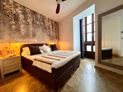 a bedroom with a large bed and a mirror at inncadiz El Refugio de Gadir in Cádiz