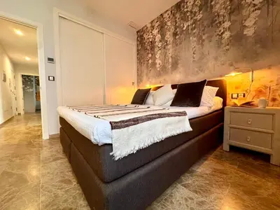 a bedroom with a large bed with a large painting on the wall at inncadiz El Refugio de Gadir in Cádiz