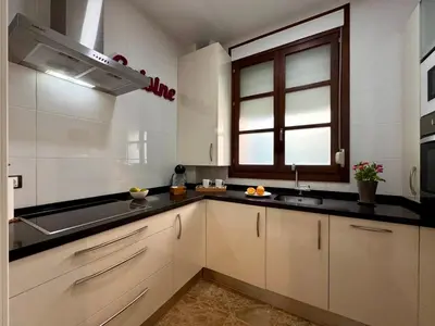 a kitchen with white cabinets and a sink and a window at inncadiz El Refugio de Gadir in Cádiz