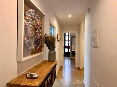 a hallway with a table and a painting on the wall at inncadiz El Refugio de Gadir in Cádiz