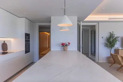 a kitchen with white walls and a large white counter top at GINVA - Luxury Beachfront Apartment in El Puerto de Santa María