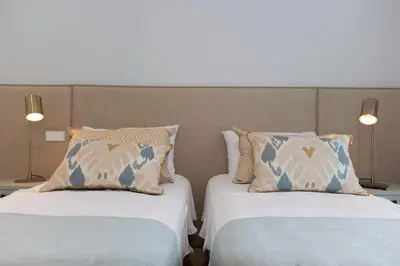 two beds sitting next to each other in a room at GINVA - Luxury Beachfront Apartment in El Puerto de Santa María