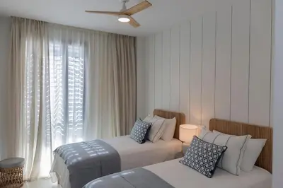 a hotel room with two beds and a window at GINVA - Luxury Beachfront Apartment in El Puerto de Santa María