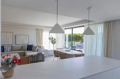 a kitchen and living room with a couch and a table at GINVA - Luxury Beachfront Apartment in El Puerto de Santa María