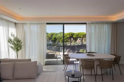 a living room with a couch and a table with chairs at GINVA - Luxury Beachfront Apartment in El Puerto de Santa María