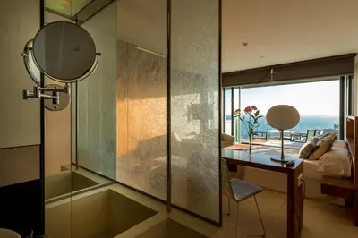 a bathroom with a shower and a desk with a mirror at Parador de Cádiz in Cádiz