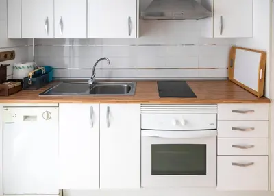 a kitchen with white cabinets and a sink at SH Brisa de la Viña. Cerca de la Playa. AC, WIFi in Cádiz