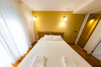 a large white bed in a room with a yellow wall at SH Brisa de la Viña. Cerca de la Playa. AC, WIFi in Cádiz