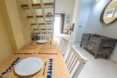a dining room with a table with white plates on it at SH Brisa de la Viña. Cerca de la Playa. AC, WIFi in Cádiz