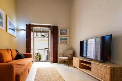 a living room with a couch and a flat screen tv at SH Brisa de la Viña. Cerca de la Playa. AC, WIFi in Cádiz