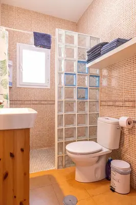 a bathroom with a toilet and a sink and a window at Parisito beach in Chiclana de la Frontera