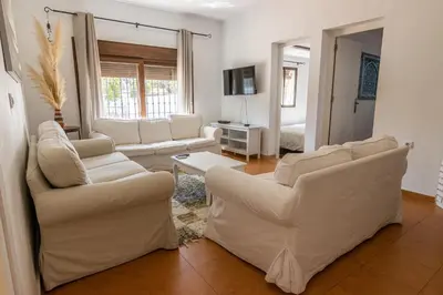 a living room with white couches and a tv at Parisito beach in Chiclana de la Frontera