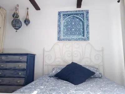 a bedroom with a bed with a blue and white headboard at Parisito beach in Chiclana de la Frontera