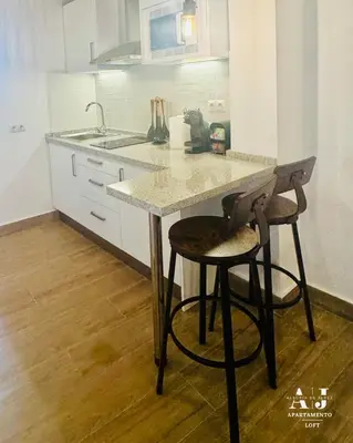 a kitchen with a counter with two stools and a sink at Apartamento con Entreplanta Alegría de Jerez in Jerez de la Frontera