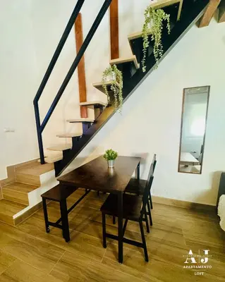 a dining room with a wooden table and stairs at Apartamento con Entreplanta Alegría de Jerez in Jerez de la Frontera
