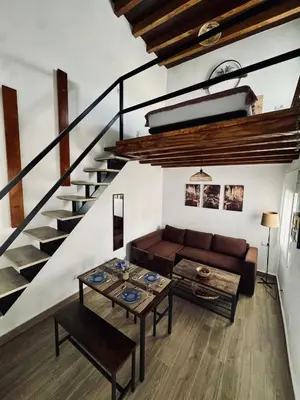 a living room with a couch and a staircase at Apartamento con Entreplanta Alegría de Jerez in Jerez de la Frontera
