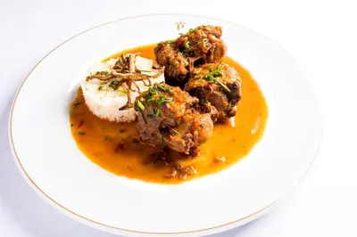 a plate of food with meatballs and gravy at Parador de Arcos de la Frontera in Arcos de la Frontera