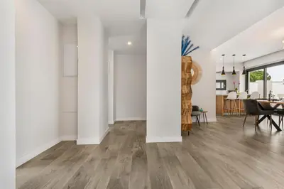 an empty living room with white walls and wood floors at Villa Paradisus Golf & Wellnes in Cádiz