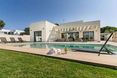 a house with a dog laying next to a swimming pool at Villa Paradisus Golf & Wellnes in Cádiz
