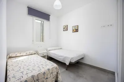 a white room with two beds and a window at Conil Seaside Hideaway in Conil de la Frontera